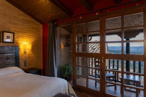 a bedroom with a bed and a large glass door at Hotel Villa de Alquézar in Alquézar
