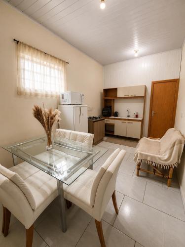 a living room with a glass table and chairs at Loft Farol in Pântano Grande