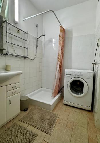 a bathroom with a washing machine and a shower at Kinizsi House in Szigetszentmiklós