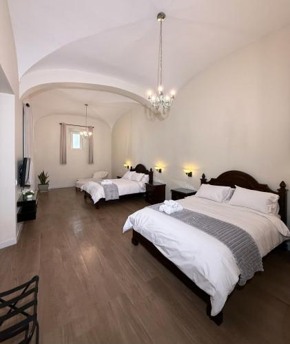 a large bedroom with two beds and a chandelier at Patrimonial Hotel Boutique in Cochabamba