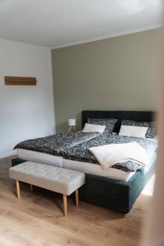 a bedroom with a bed with a bench next to it at "LOKAL" Apartment 1 in Bad Muskau