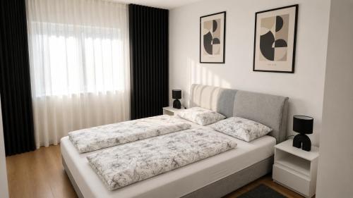 a white bed in a room with a window at Apartmani Natura SH in Hodžinac