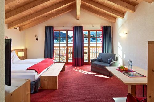a hotel room with a bed and a couch at HOTEL Der Waldhof - Unique - A hidden gem - nature - organic - Eco in Sankt Anton am Arlberg