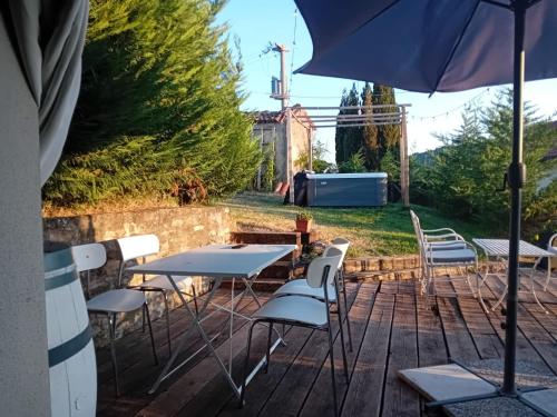 a patio with tables and chairs and an umbrella at Cà Tinola in Mango