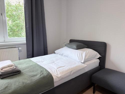 a bedroom with a bed and a window and a chair at Apartman H4 in Žilina