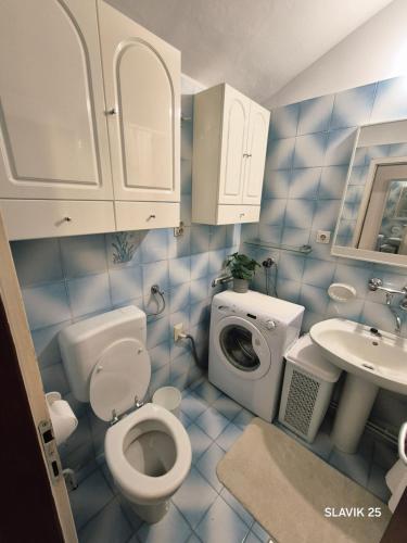 a blue tiled bathroom with a toilet and a sink at Kuća za odmor SLAVIK in Daruvar