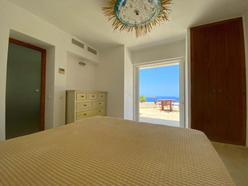 a bedroom with a bed with a view of the ocean at Ibiza 7th Heaven Villa in Sant Josep