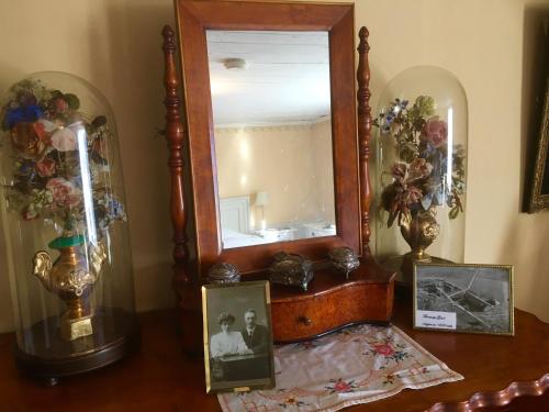 a mirror sitting on top of a table with pictures at Thorstorps Gård B&B in Söderköping