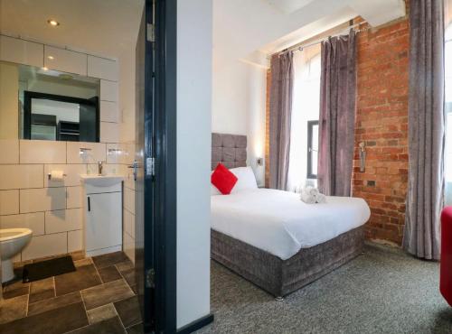 a hotel room with a bed and a bathroom at Kick back relax stylish space in Nottingham