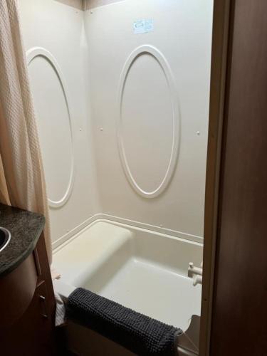 a bathroom with a bath tub and two round windows at The Boardwalk in Westfield Beach