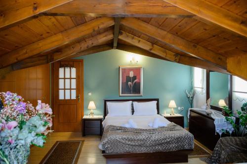 a bedroom with a bed in a room with wooden ceilings at Soffitta House Sofi! in Florina