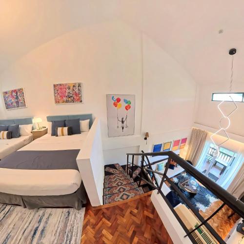 a loft bedroom with a bed and a staircase at Raffy White Boracay in Boracay