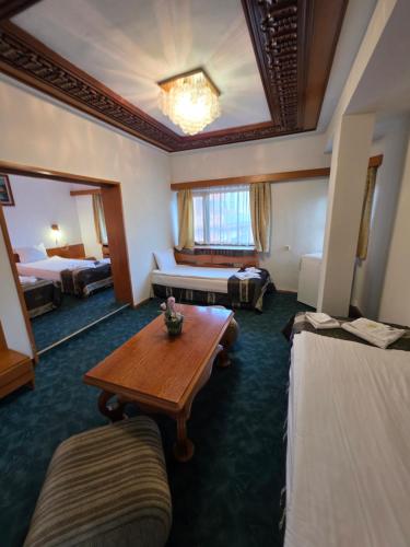 a hotel room with a table and a bed at Комплекс ,,Трявна" in Tryavna