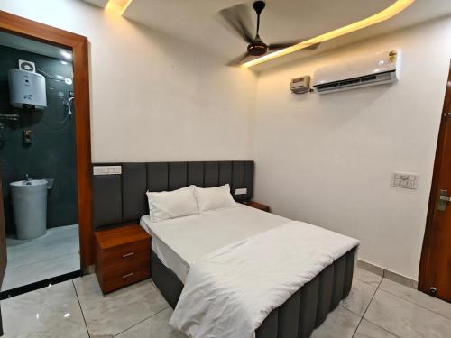 a small bedroom with a bed and a bathroom at Ora Stay in Pānīpat