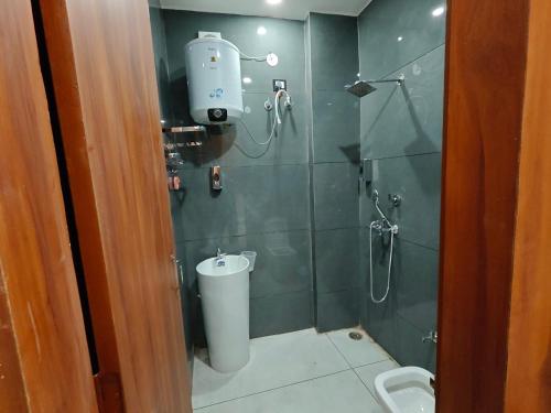 a bathroom with a shower with a toilet and a sink at Ora Stay in Pānīpat