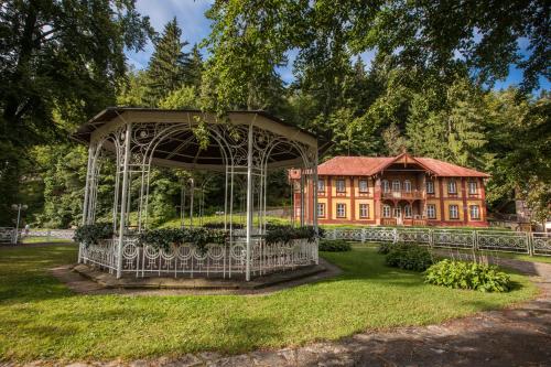 a gazebo in front of a large house at Réva in Janske Lazne