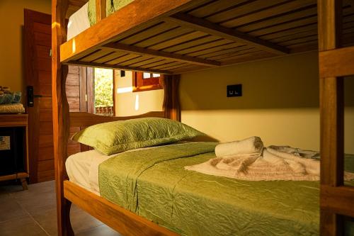 a bedroom with a bunk bed with a green comforter at Hotel Pousada Flor de Alecrim - Goiana in Goiana