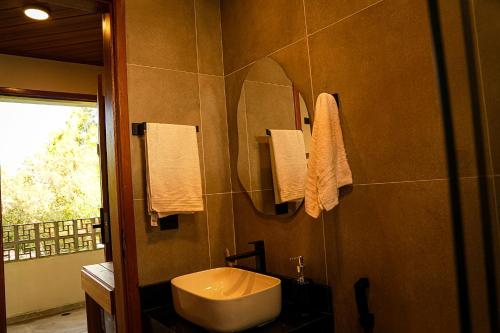 a bathroom with a sink and a mirror at Hotel Pousada Flor de Alecrim - Goiana in Goiana