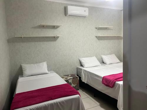 two beds in a small room with shelves at Chácara HZ in Sao Jose do Rio Preto