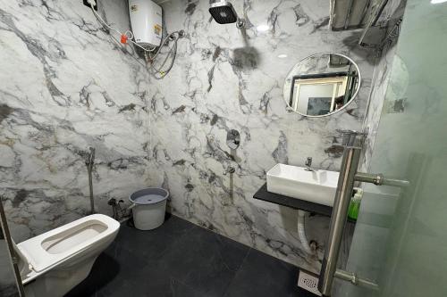 a bathroom with a sink and a toilet and a mirror at Hotel Anantshree Inn Shree Mahakaleshwar Temple Ujjain in Ujjain