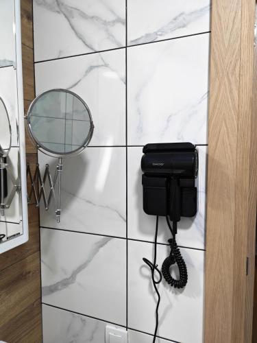 a phone on a wall next to a mirror at KM Lux & SPA in Veliko Gradište