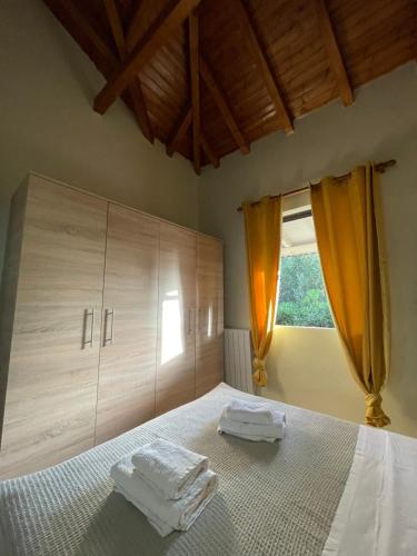 a bedroom with a bed with two towels on it at Olive & Sea Villa Koroni in Koroni