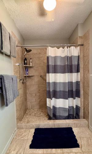 a bathroom with a shower with a shower curtain at Pine Bluff on the Lake in Golden