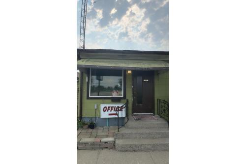 a building with a sign that reads office at Queen's Motel Blenheim Near Lake Erie ON in Blenheim