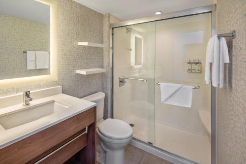 a bathroom with a shower and a toilet and a sink at Holiday Inn Express Toronto Downtown by IHG in Toronto