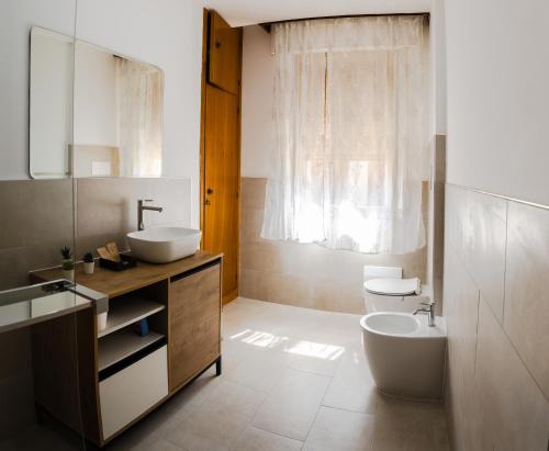ein Badezimmer mit Waschbecken, Toilette und Badewanne in der Unterkunft Alifrasi in La Caletta