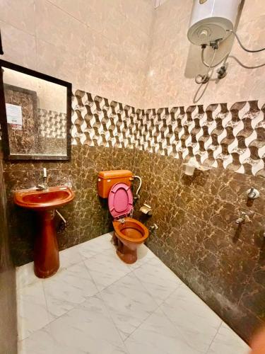 a bathroom with a toilet and a sink at crown house in Phagwāra