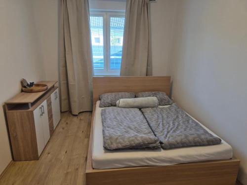a small bedroom with a bed and a window at Riverside house Duna in Rajka