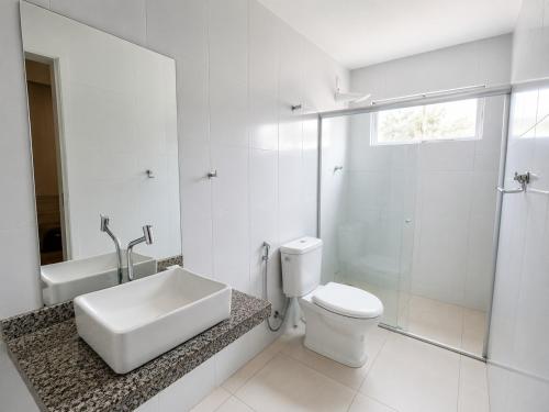 a bathroom with a toilet and a sink and a shower at Hotel Itaparica in Caruaru