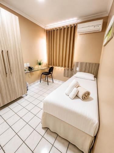 a hotel room with a bed and a desk at Hotel Itaparica in Caruaru