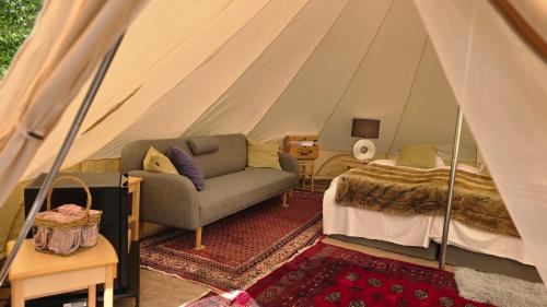 a room with a tent with a couch and a bed at Norrqvarn Hotel & Resort by Vänerport in Lyrestad
