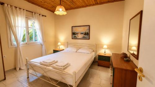 ein Schlafzimmer mit einem weißen Bett und einem Fenster in der Unterkunft Villa Vanda in Ligia