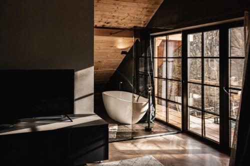 a bathroom with a tub and a large window at Amber Hills Romania in Braşov