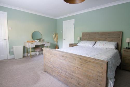 a bedroom with a large wooden bed and a desk at Coopers by the Coast in Selsey