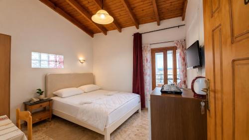 a bedroom with a bed and a desk and a television at Diporto in Chania