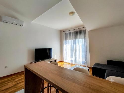 a living room with a table and a flat screen tv at Modern Luxury Apartment with Private Garage in Stara Varoš