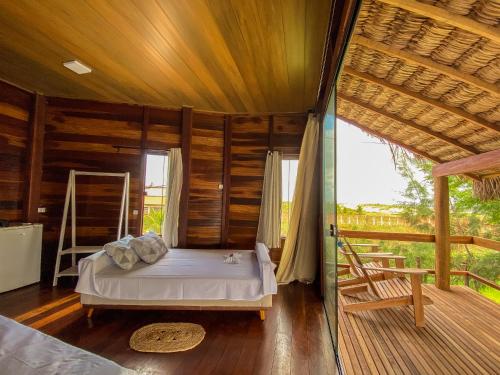 a bedroom with a bed in a room with wooden walls at Pousada Delta Chalés in Tutóia