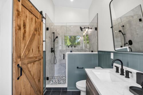 a bathroom with a shower and a toilet and a sink at Cambridge Cabin in Stanton