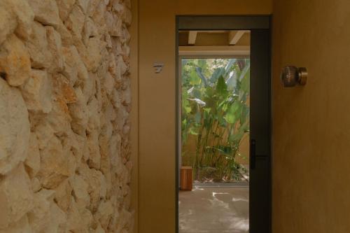 a door leading into a room with a stone wall at Arde La Selva in Santa Fe de Antioquia