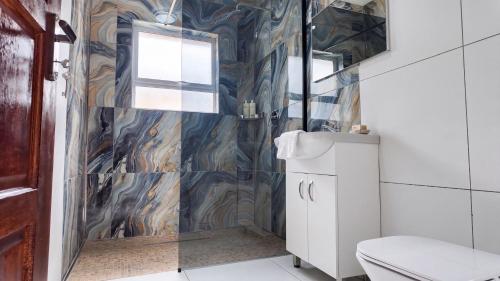 a bathroom with a toilet and a glass shower at Saob Property in Germiston