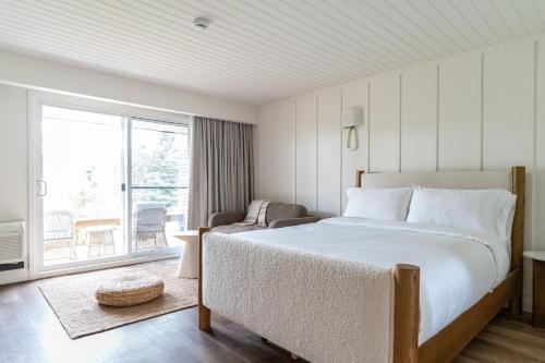a bedroom with a large bed and a balcony at Sand and Stone Resort in Huntsville