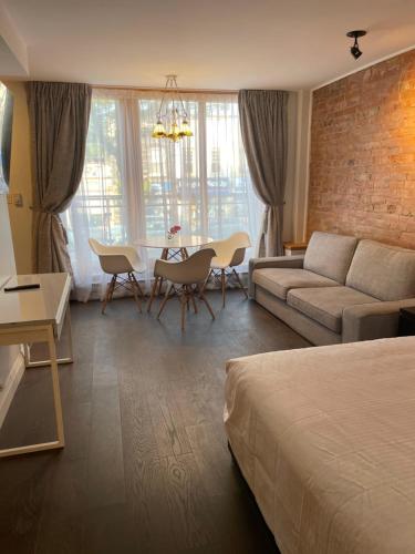 a living room with a bed and a couch and a table at Cabbagetown Inn in Toronto