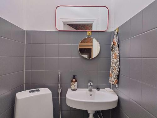 a bathroom with a sink and a toilet and a mirror at Heritage House at Villa Sofia in Lahti