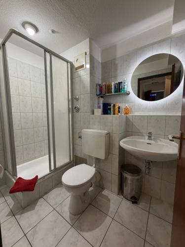 a bathroom with a toilet and a sink at Pension Ksenija Hanau in Hanau am Main