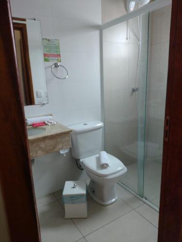 a bathroom with a toilet and a glass shower at Villarejo Parque Hotel in Penha