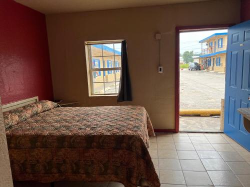 a bedroom with a bed and a door to a street at Holiday Motel Tulsa OK in Tulsa